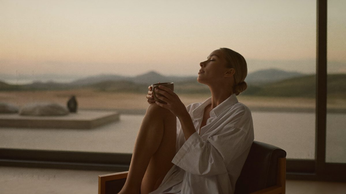 A person relaxing at night with tea and eyes closed, phone away